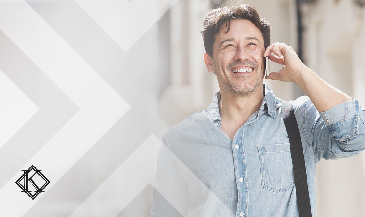 A imagem mostra um homem sorrindo e caminhando na rua enquanto atende o telefone, e ilustra a publicação 