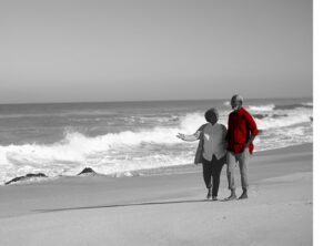 A imagem mostra um casal na beira da praia, e ilustra a publicação 