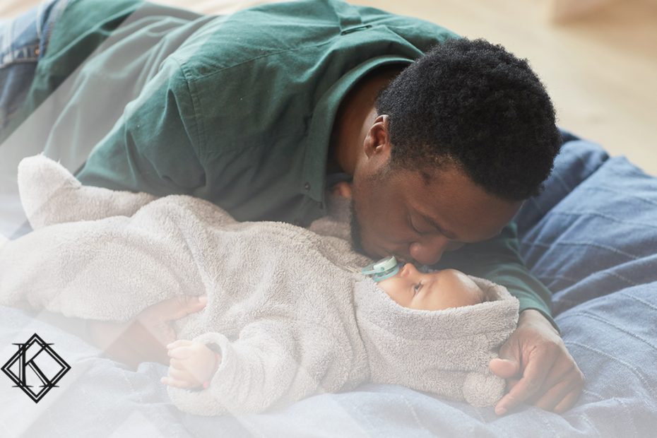 A imagem mostra um homem beijando um bebê na testa, e ilustra a publicação "Visto permanente por reunião familiar no Brasil, como obter?", da Koetz Advocacia.