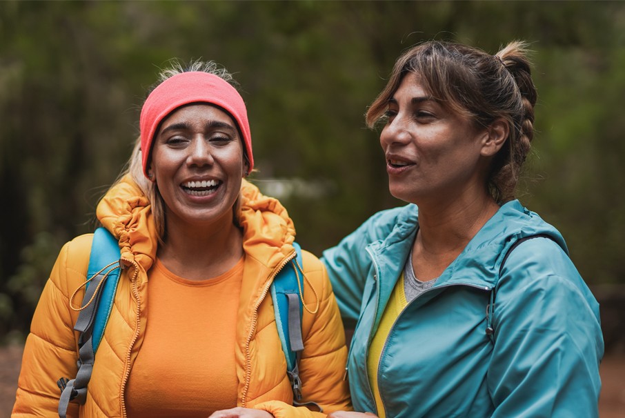 A imagem mostra duas mulheres em uma trilha na floresta