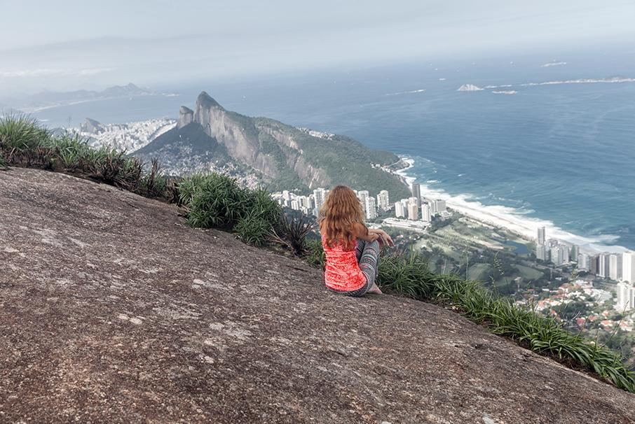 A imagem mostra uma menina no alto de um monte, admirando a vista. A imagem ilustra o texto 