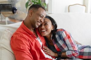 The image shows a couple embracing on the sofa. Text image 