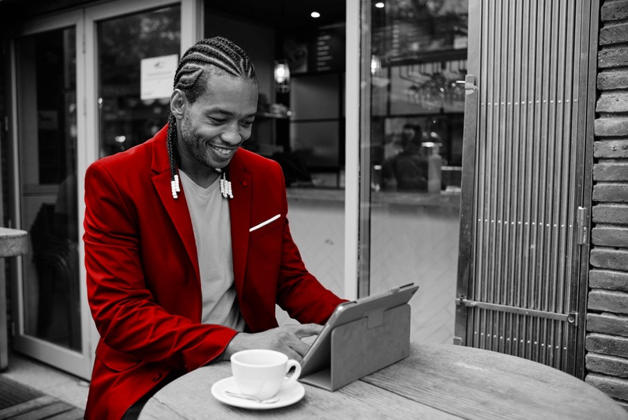 A imagem mostra homem adulto em uma cafeteria com seu tablet. A imagem ilustra o texto 
