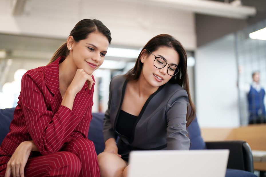 A imagem mostra dois mulheres em um ambiente empresarial, olhando para a tela de um notebook e ilustra o texto: Empresas internacionais no Brasil da Koetz Advocacia.