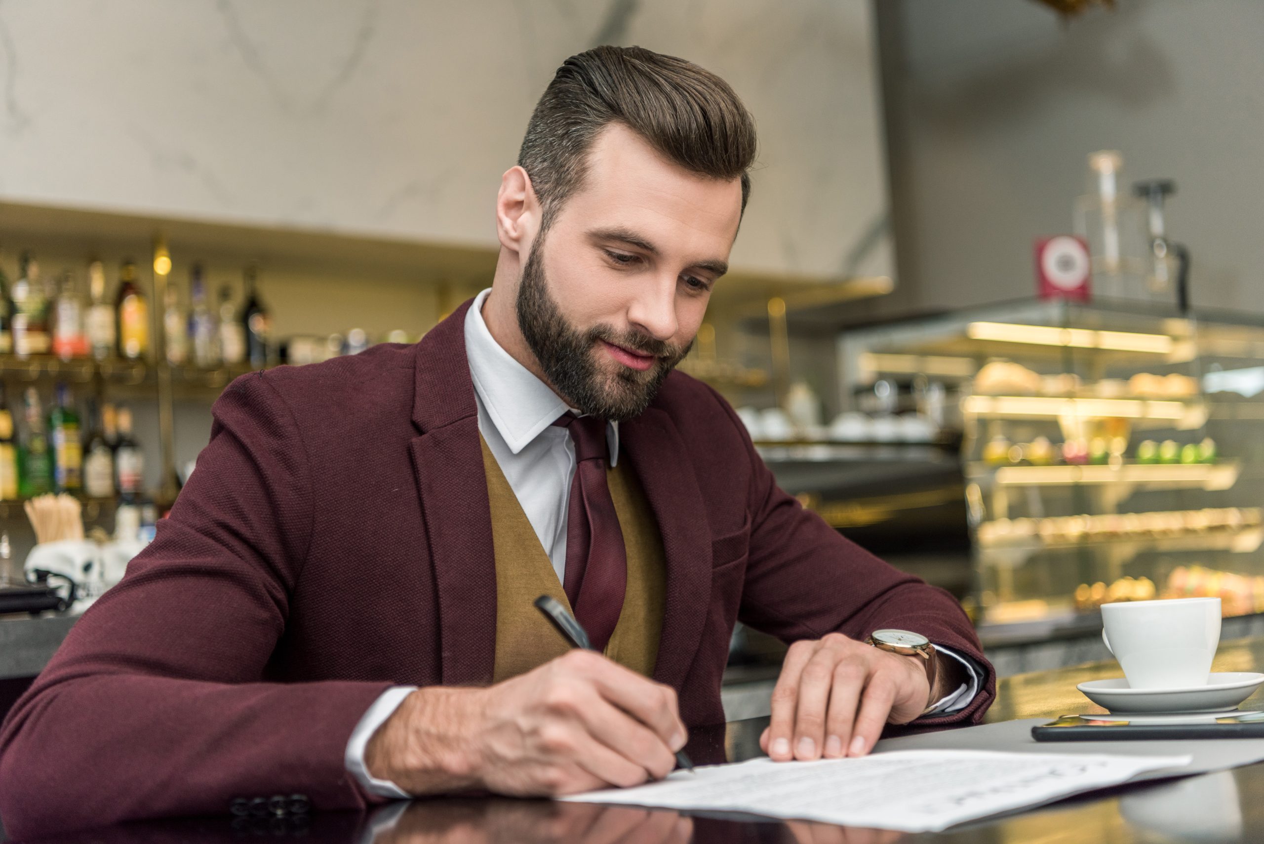 A imagem mostra um homem vestido de forma formal, assinando um contrato e ilustra o texto: Tudo o que você precisa saber sobre reconhecimento de contrato celebrados no estrangeiro da Koetz Advocacia.