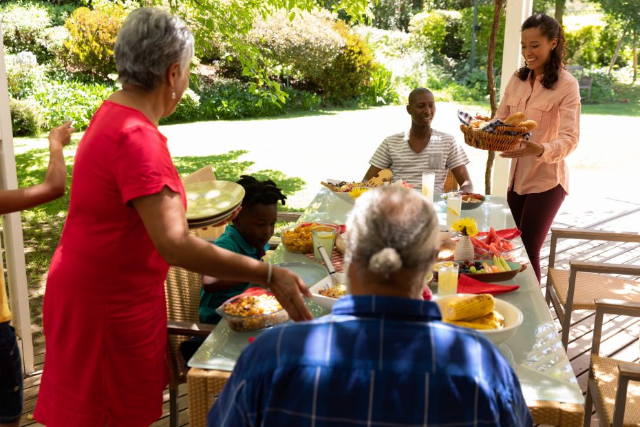 A imagem mostra uma família em volta de uma mesa, com comida, ao ar livre e ilustra o texto: Vantagens da Sucessão Familiar no Brasil – comparativo com a Europa da Koetz Advocacia.