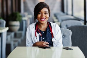 A imagem mostra uma médica mulher, sorrindo para a câmera. A imagem ilustra o texto Visto para aperfeiçoamento médico no Brasil de Koetz Advocacia