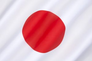 A imagem mostra a bandeira do Japão em destaque e ilustra o texto: Crimes in Japan that are not crimes in Brazil da Koetz Advocacia.