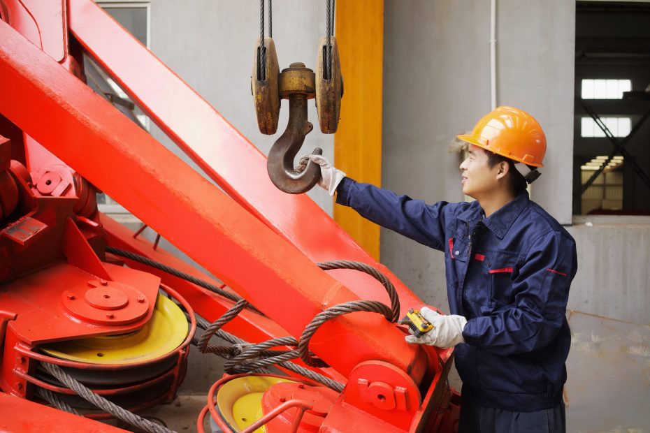 A imagem mostra um trabalhador usando equipamentos em instalações de fabricação de guindastes, na China e ilustra o texto: Passo a passo de como importar da China da Koetz Advocacia.