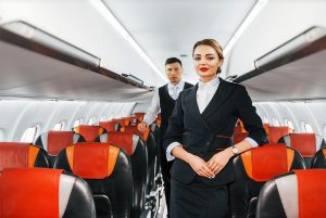 The image shows a flight attendant at her work on the plane, illustrating the article 