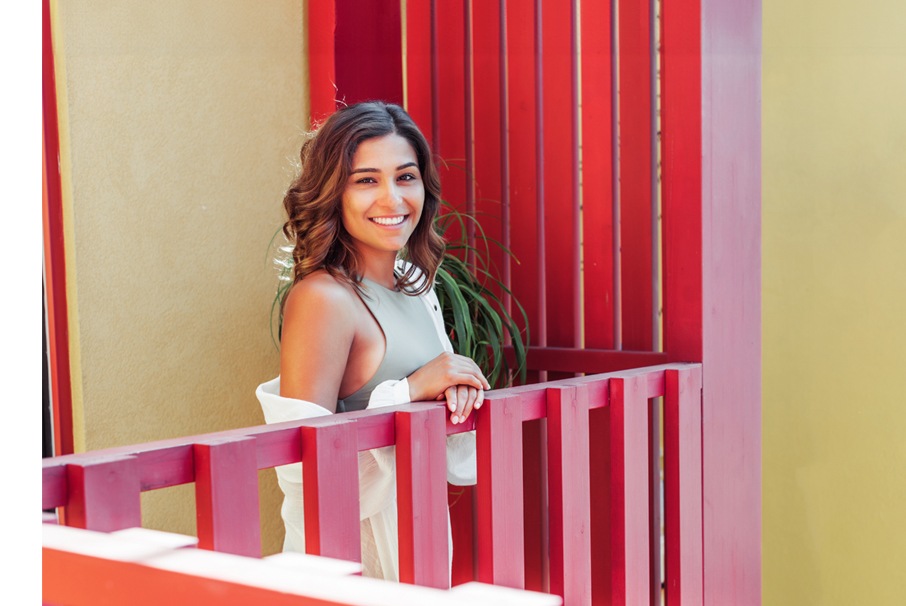 La imagen muestra a una joven disfrutando del sol en su balcón. ilustrando el articulo "Lugares para vivir en Brasil: ¡consejos para que los extranjeros elijan!" Koetz Advocacia
