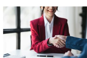 La imagen muestra a una empresaria dándose la mano de acuerdo con el resultado de la reunión. ilustrando el articulo 