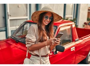 The image shows a smiling young woman with her cell phone. The image illustrates the text 