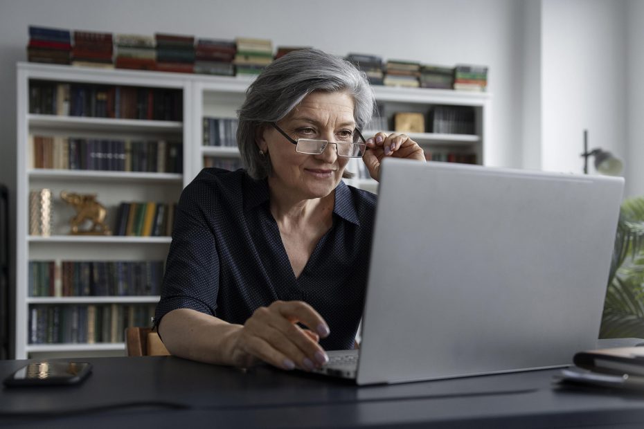 A imagem mostra uma mulher na melhor idade fazendo uma pesquisa no computador, e ilustra a publicação "Onde fazer testamento em vida?", da Koetz Advocacia, que explica onde, como fazer e qual o valor de um testamento.