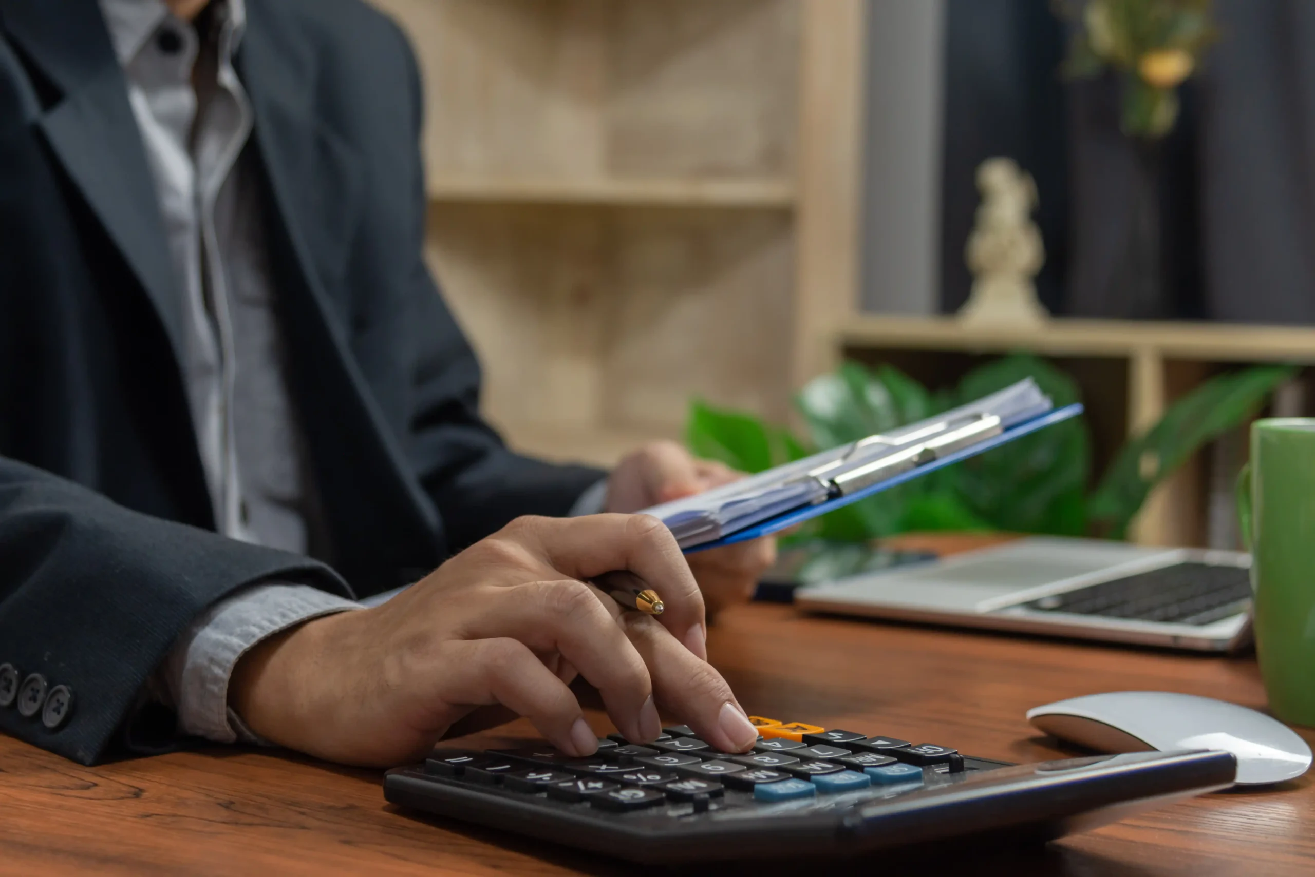 La imagen muestra las manos de un hombre de negocios haciendo finanzas y calculando el costo en el escritorio de la oficina. E ilustra el texto sobre Impuesto sobre sucesiones en el mundo.