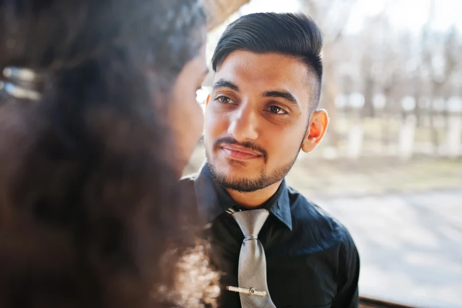 La imagen muestra a una joven pareja enamorada, mirándose. Ilustra el texto sobre inmigrante.