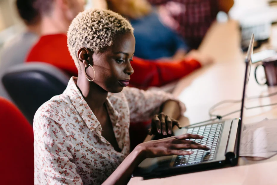 La imagen muestra a una mujer joven en un entorno de trabajo, utilizando una computadora portátil e ilustra el texto: Guía de exportación de software de Koetz Advocacia.