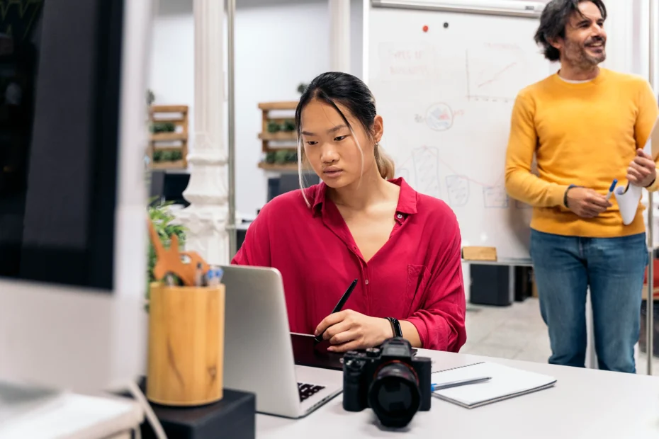 The image shows a young Asian woman working in an office. It illustrates the text about how can a foreigner work in Brazil.