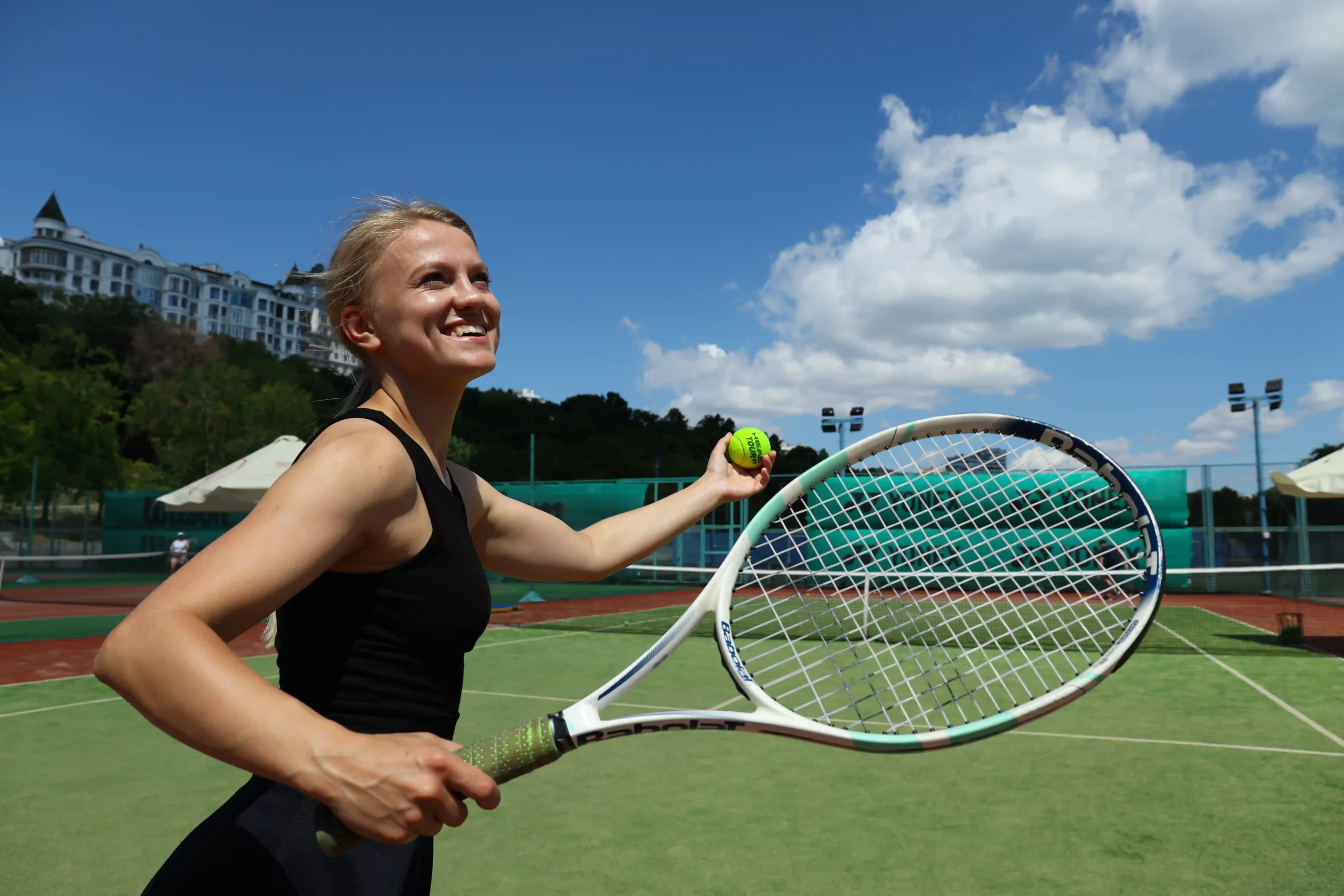 A imagem mostra uma jovem mulher sorridente jogando tenis. E ilustración o texto sobre visa brasileña para fines artísticos o deportivos.