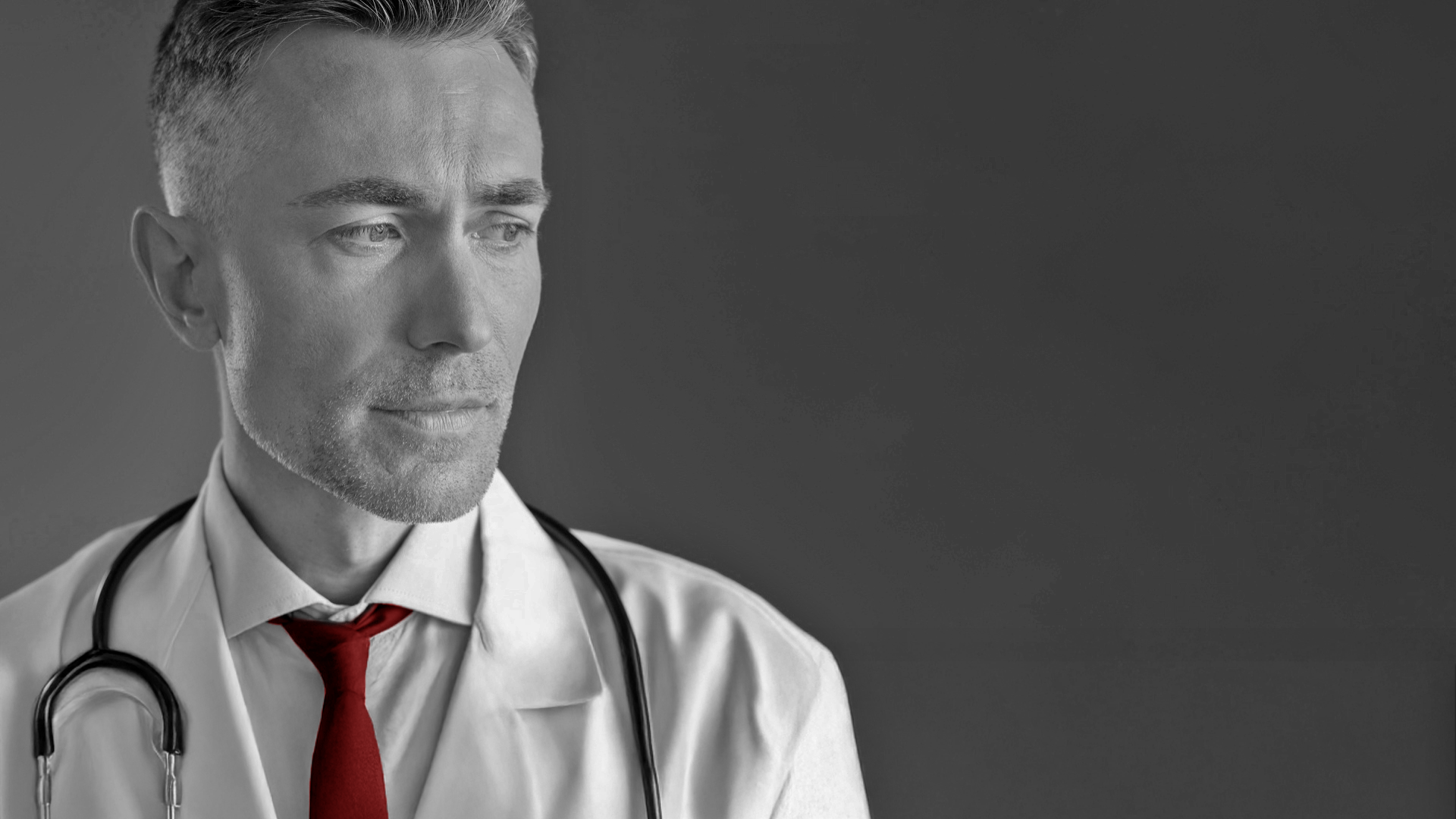 A imagem mostra um médico preocupado, olhando para o lado. Ele usa jaleco, gravata e estetoscópio.