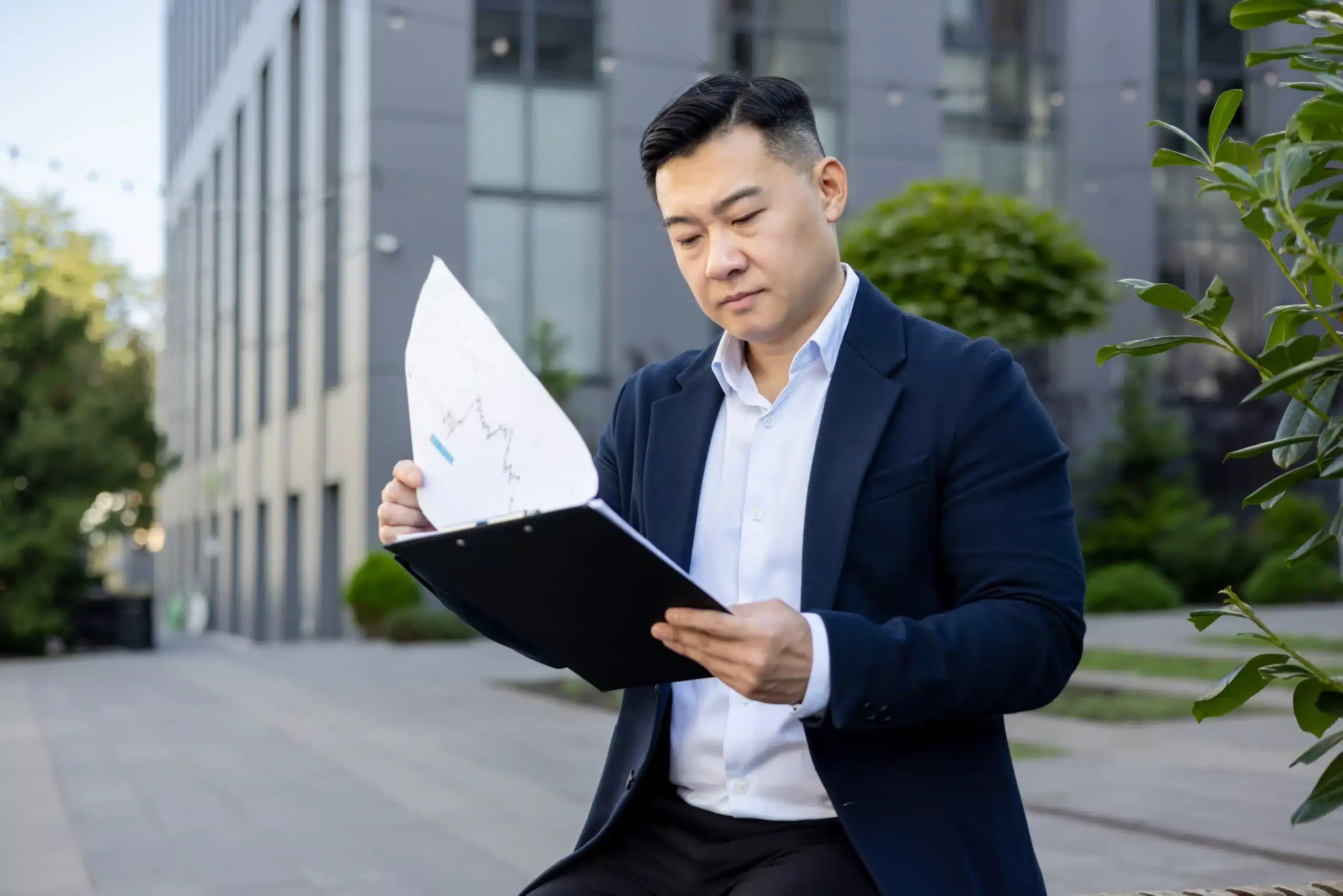 La imagen muestra a un empresario asiático al aire libre revisando documentos. Ilustra el texto sobre la terminación del contrato.