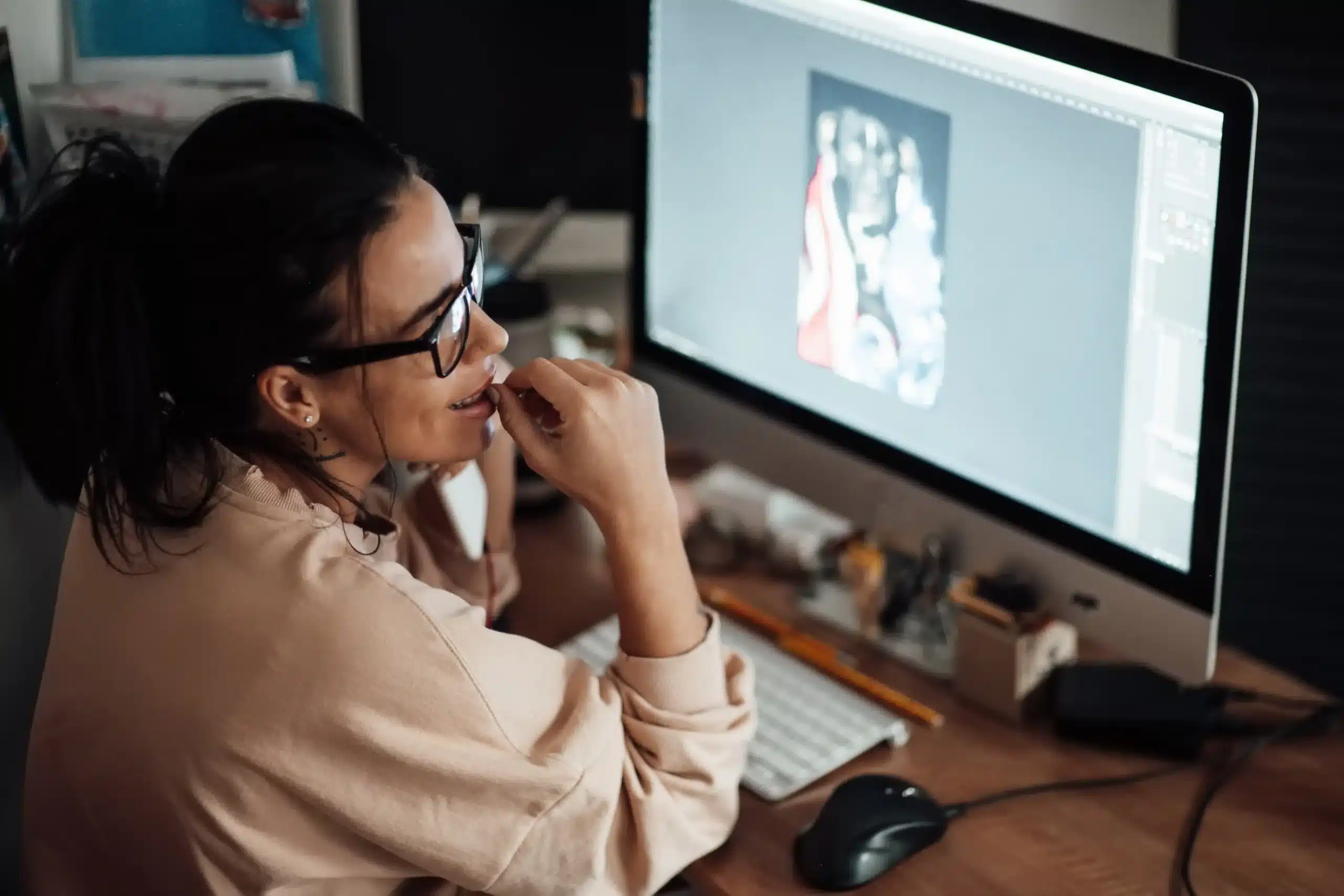 La imagen muestra a una mujer con gafas trabajando frente a una computadora. Ilustra el texto sobre extranjero trabajar en Brasil.