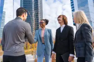 La imagen muestra a cuatro socios conversando, vestidos de gala. Ilustra el texto de contrato social.