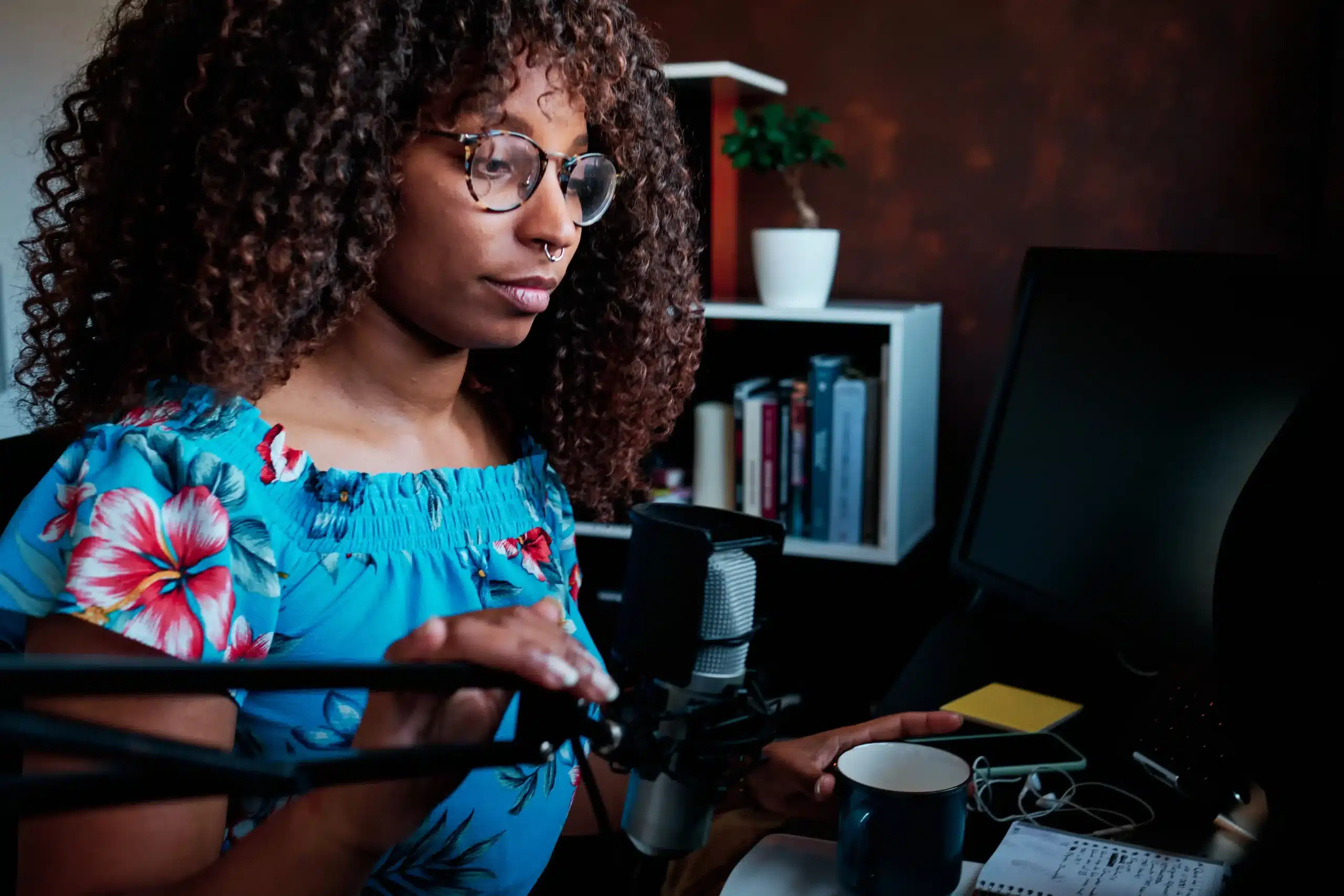 The image shows a young woman using a microphone and computer while broadcasting a podcast from home. It illustrates the text about foreigner to work in Brazil.