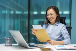 The image shows a young woman working in a corporate environment. It illustrates the text about hiring refugees.