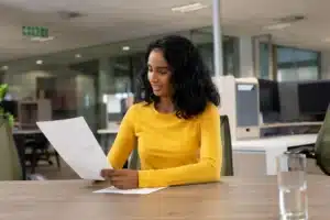 La imagen muestra a una joven analizando documentos y resalta el texto sobre el Documento de Registro Nacional de Migración Provisional.