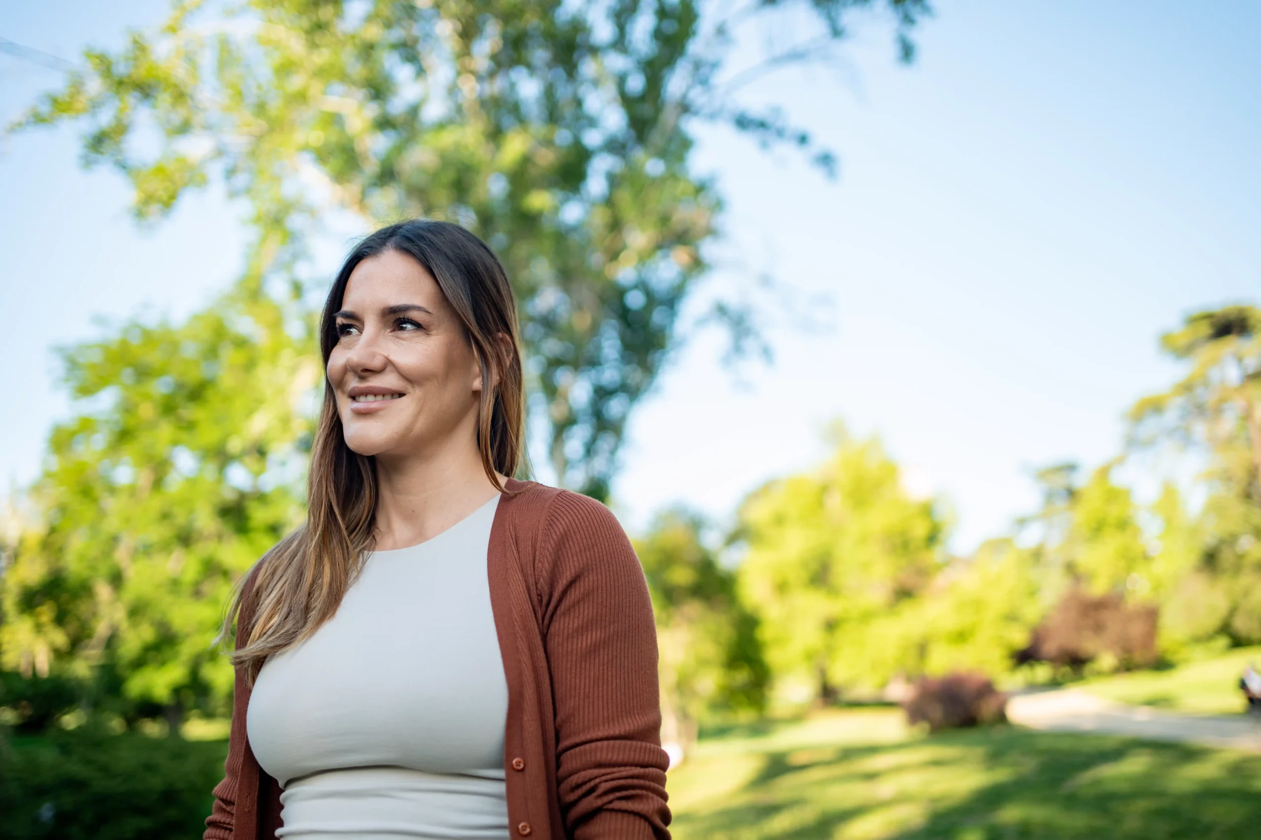 The image shows a smiling woman outdoors. It illustrates the text about refugees.