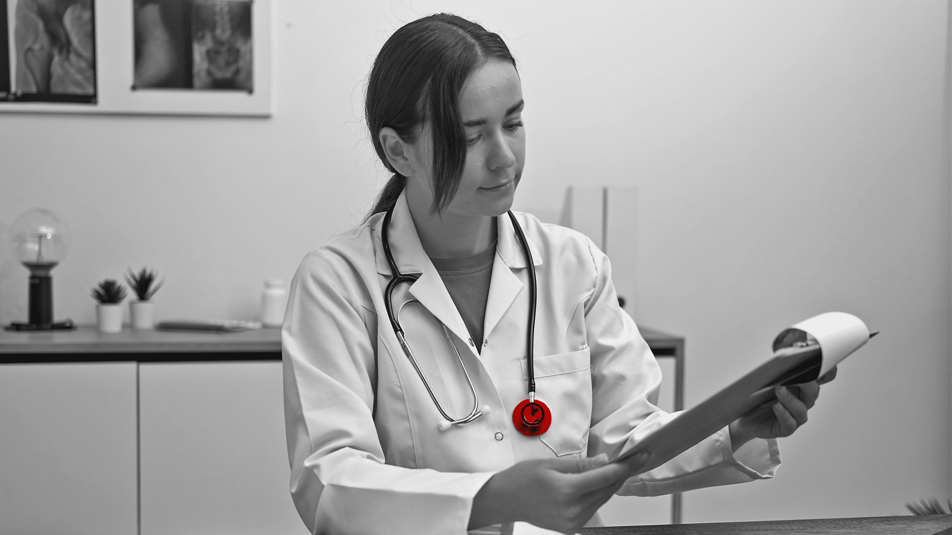 A imagem mostra uma jovem médica, de jaleco, usando estetoscópio em volta do pescoço, em seu consultório, checando uma prancheta.