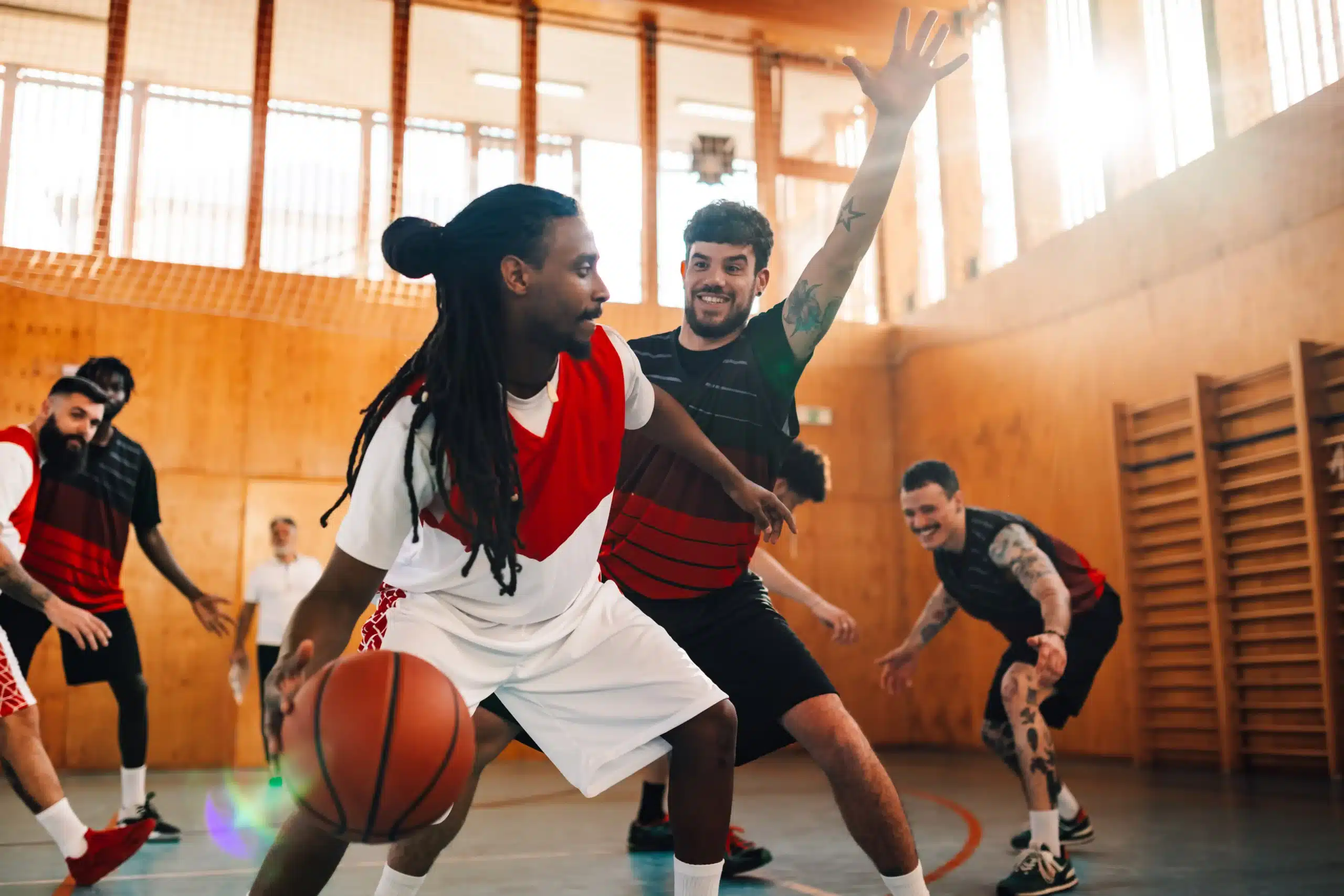 The image shows athletes playing basketball on a sports court. It illustrates the text about the visa for athletes.