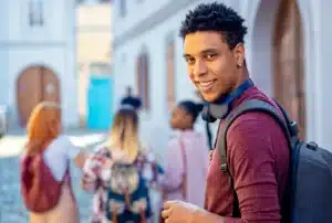 The image shows a smiling young African-American student with friends looking at the camera. It illustrates the text about Brazilian Visa for Research.