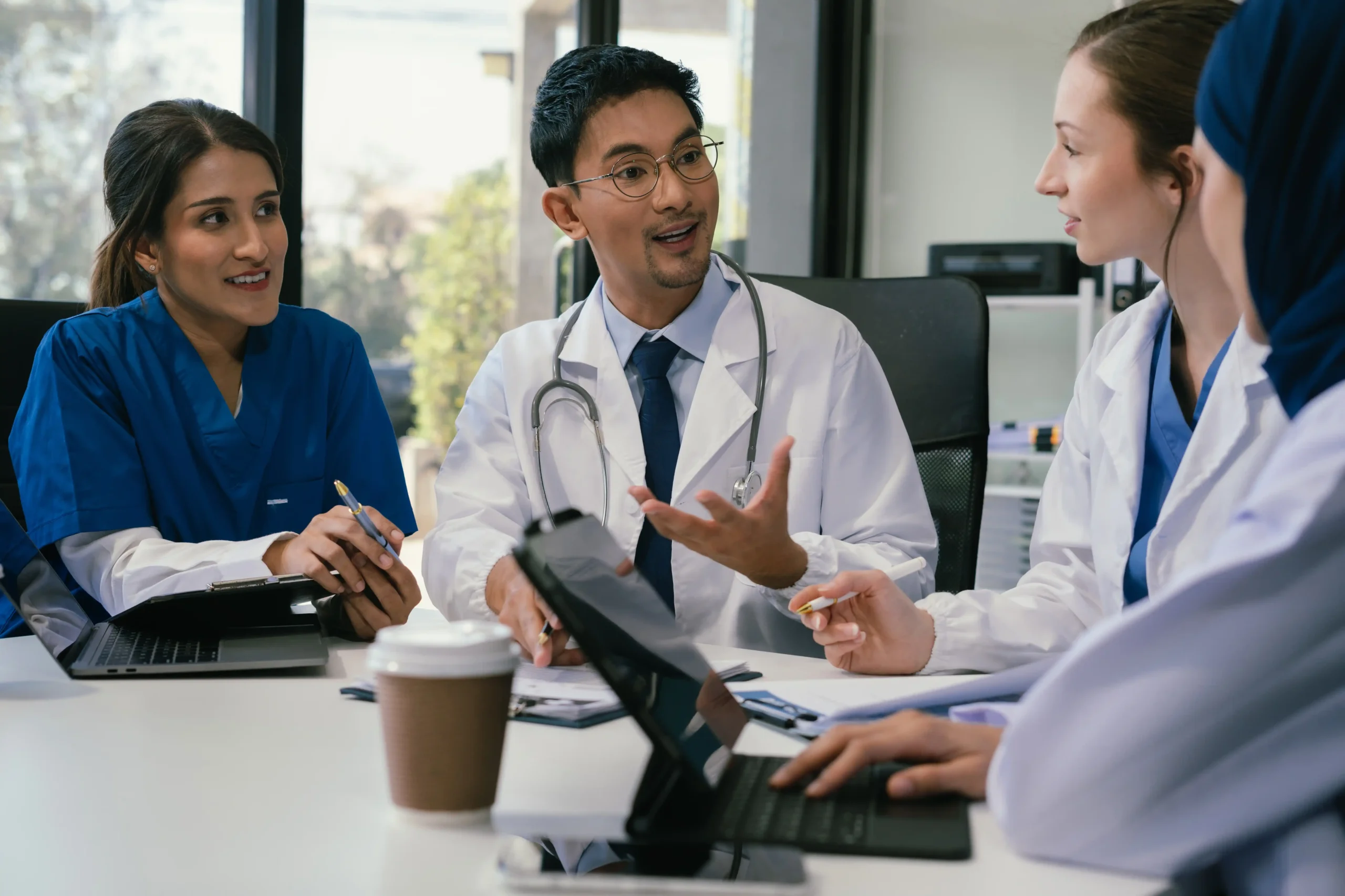 A imagem mostra um grupo de médicos em uma reunião. Ilustra o texto sobre contrato de aluguel de consultório médico.