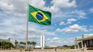 The image shows the Brazilian flag flying, fluttering in the wind, in the capital, Brasília. It illustrates the text about activities exclusively for Brazilians.